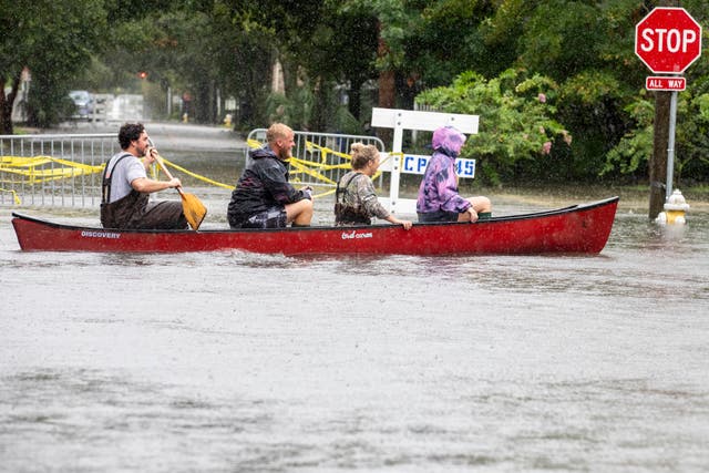 <p>Four people paddle through a flooded street in Charleston, South Carolina as Tropical Storm Debby hovers off the state’s coast</p>