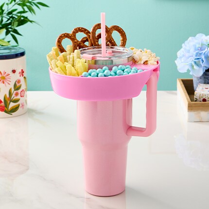 pink tumbler with snack tray filled with food