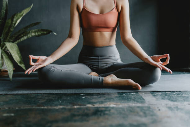 Fotografia Anonymous Woman Doing Yoga at Home: Lotus Position