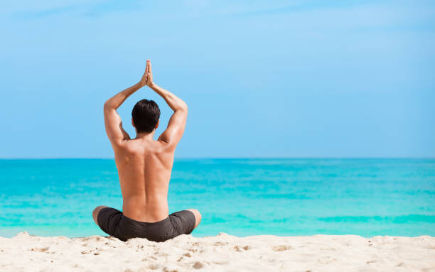 Fotografia Man meditating on the beach