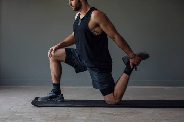 Fotografia Muscular Sportsman Stretching his Legs to