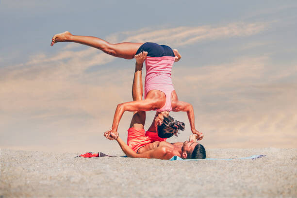 Fotografia Young sporty couple practicing acroyoga exercises