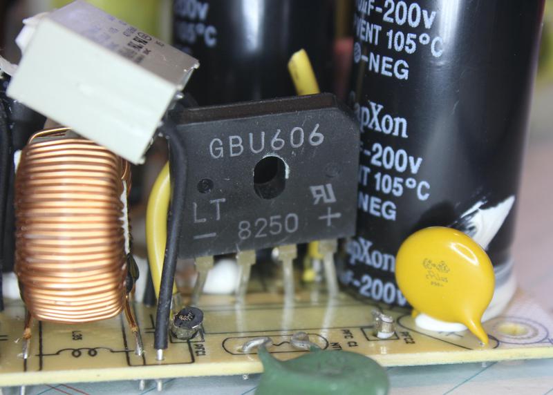 The bridge rectifier is labeled "GBU606". Filter circuitry is to its left. To the right, the large black cylinder is one of the voltage-doubler capacitors.
The small yellow capacitor is a special Y capacitor, designed for safety.