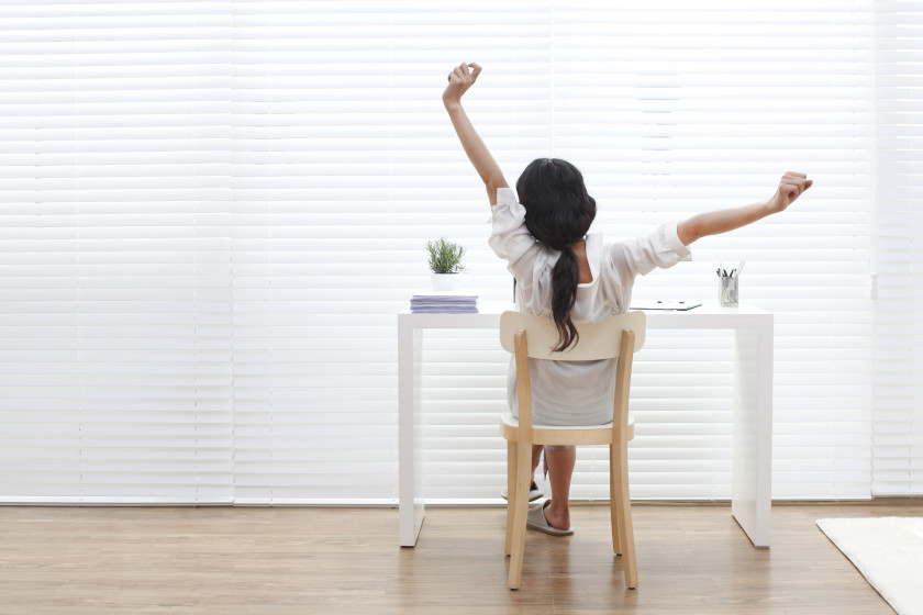 A woman stretching while studying