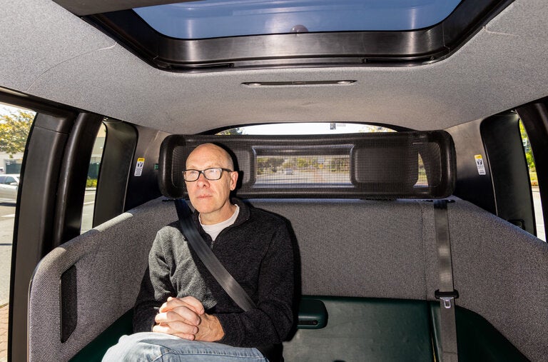 The New York Times reporter Cade Metz riding in a Zoox robot taxi in Foster City, Calif.