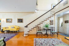 The foyer features a grand staircase, connects the main living spaces and leads to the front entryway and the back porch, which opens to a flower garden.