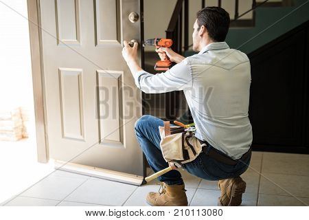 Young Man Fixing A Door Lock