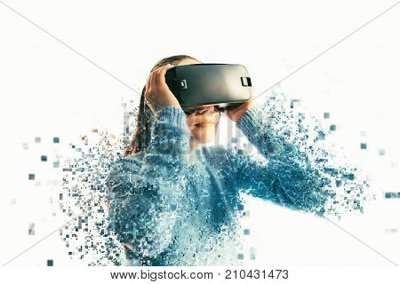 A person in virtual glasses flies to pixels. The woman with glasses of virtual reality. Future technology concept. Modern imaging technology. Fragmented by pixels