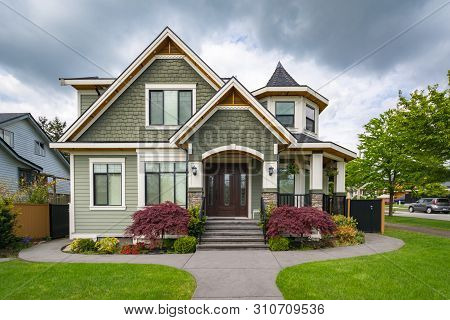 Residential Family House With Concrete Pathway Over Green Lawn. Family House With Car Parked On Side