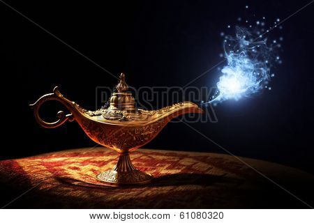 Magic lamp from the story of Aladdin with Genie appearing in blue smoke concept for wishing, luck and magic