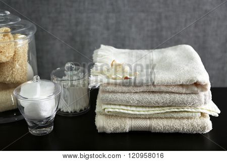 Bathroom set with towels, wisps and sponges on grey background