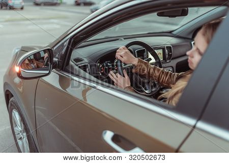 A Girl Driving A Car, Looks In A Side View Mirror, Parking At A Shopping Center, Turning At An Inter