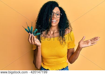 Middle age african american woman holding picklock to unlock security door celebrating achievement with happy smile and winner expression with raised hand 