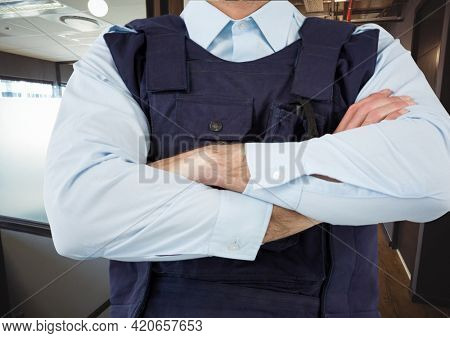 Composition of midsection of male security guard in bullet proof vest over office background. security and safety concept digitally generated image.