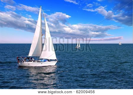 Sailboat sailing in the morning with blue cloudy sky