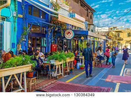 TEL AVIV ISRAEL - FEBRUARY 25 2016: The flea market neighborhood of old Jaffa is full of the cozy cafes decorated with plants in pots colorful rugs and wooden details on February 25 in Tel Aviv.