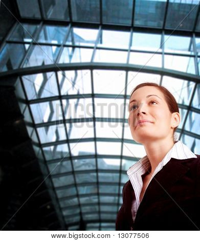 Young and ambitious businesswoman looks at the future in front of an office building.