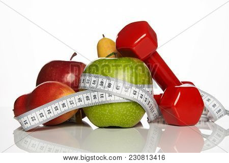 Fitness Equipment And Healthy Food Isolated On White. Red Dumbbells With Fresh Fruit And Green Apple