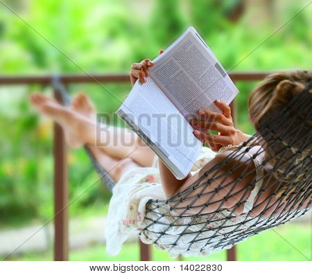 Jonge vrouw lezen van een boek liggend in een hangmat