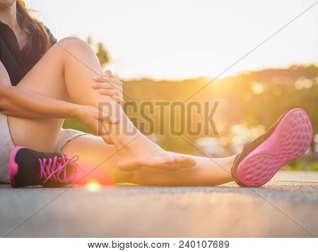 Running Injury Leg Accident- Sport Woman Runner Hurting Holding Painful Sprained Ankle In Pain. Fema