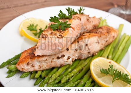 healthy salmon with coriander garnished with asparagus and lemon