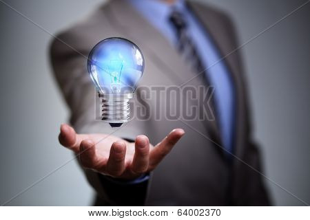 Businessman with illuminated light bulb concept for idea, innovation and inspiration