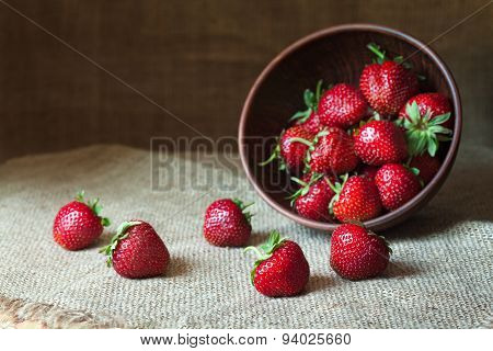 Strawberry natural healthy nutrition organic food in rustic clay dish on vintage kitchen background.