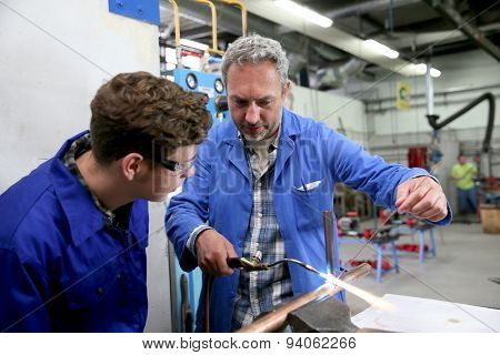 Teacher with student in metallurgy workshop