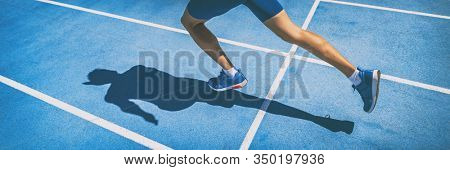 Sprinting man runner sprinter athlete running shoes and legs on track and field lane run race competing fast panoramic banner background.