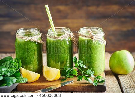 Fresh healthy green spinach and apple smoothie served in jar with lemon for diet and detox.Smoothie fruit detox breakfast. Green smoothie detox diet. Diet fruit and vegetable smoothie. Green Smoothie. Green detox diet smoothie. Green vegie smoothie detox.