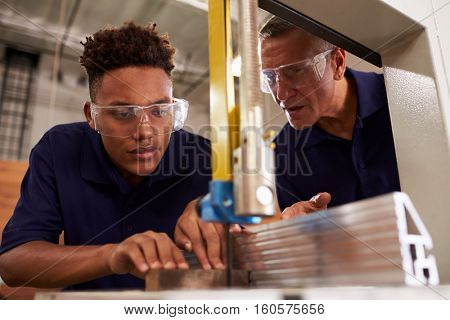 Carpenter Training Male Apprentice To Use Mechanized Saw