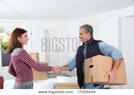 Young woman with removal man holding boxes