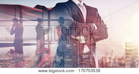 superhero businessman looking at city skyline at sunset. the concept of success, leadership and victory in business.