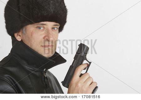 A man in Russian clothing complete with a 9mm automatic handgun