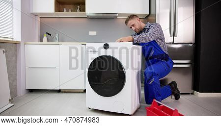 Washing Machine Repair Problem. Man Fixing Appliance