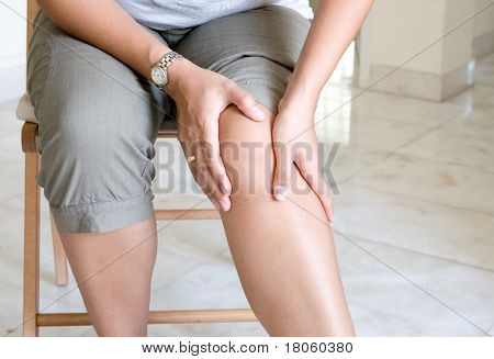 Woman suffering from pain in knee joint.