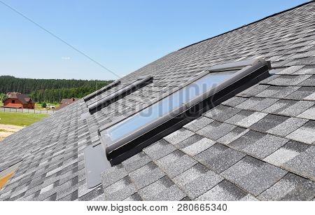 Skylights Windows On Modern House Roof Top.  Attic Skylight Windows On Asphalt Shingles Roof.