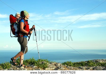 Mum walks with the child in the child carrying it.