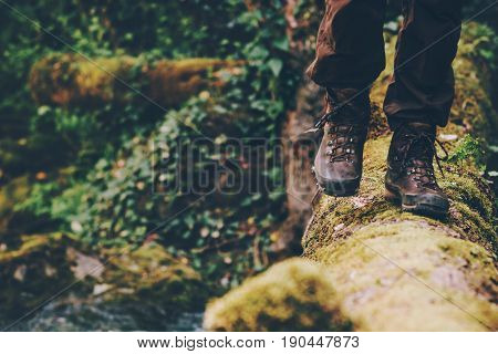 Man Traveler crossing over river on woods outdoor in wild forest Lifestyle Travel extreme survival concept summer adventure vacations