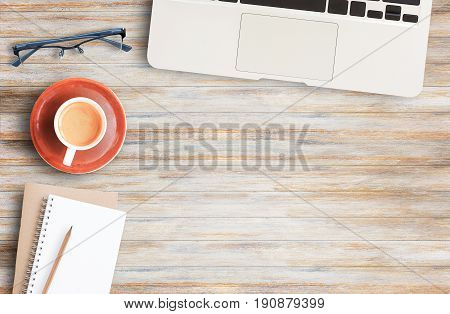 Wood office desk table with laptop computer cup of coffee and glassesflat lay. Top view with copy space (selective focus). Office desk table concept.