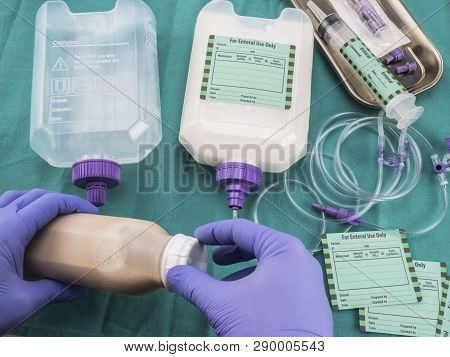 Nurse Filling A Bottle Of Enteral Nutrition, Palliative Care, Conceptual Image, Horizontal Compositi