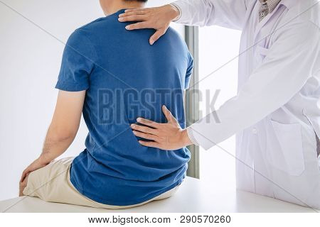 Doctor Physiotherapist Treating Lower Back Pain Patient After While Giving Exercising Treatment On S