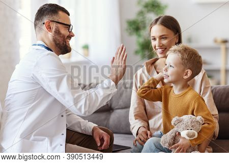 Family Doctor Pediatrician Conducts Examination Of Child Boy Who Came With His Mother,  And Giving H