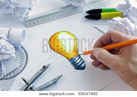 Designer drawing a light bulb, concept for brainstorming and inspiration