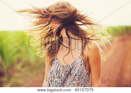 Gorgeous Romantic Girl Outdoors. Beautiful  Model in Short Dress in Field. Long Hair Blowing in the Wind. Backlit, Warm Color Tones