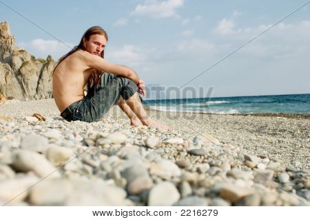 Jonge Man zittend op het strand