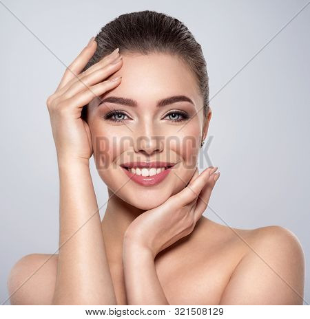 Beauty face of the young beautiful smiling woman  with a fresh healthy skin. Closeup portrait of an attractive caucasian female. Skin care concept. Woman with a smokey eye makeup. Beauty treatment.