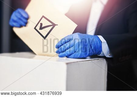 A Person In Medical Gloves Voting. Election Concept. Presidential Or Parliament Election. A Voter Pu