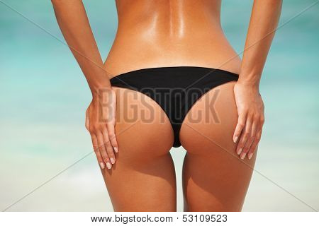 Sexy woman buttocks on the beach background