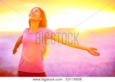 Happy people - free woman enjoying nature sunset. Freedom and serenity concept with female model in ecstatic enjoyment. Mixed race Asian Caucasian female model in 20 enjoying sunset, Grand Canyon, USA